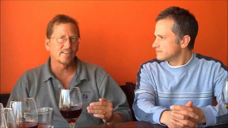 Two men discussing wine in a casual setting.