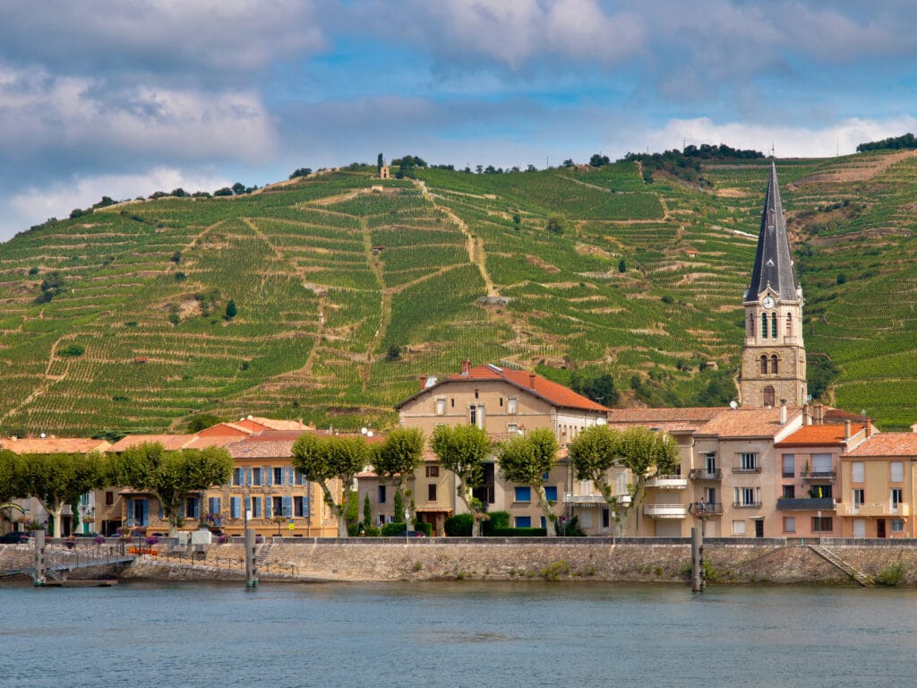 A Riverside Village And Vineyards On The Hills Of The Cote Du Rhone Area In France