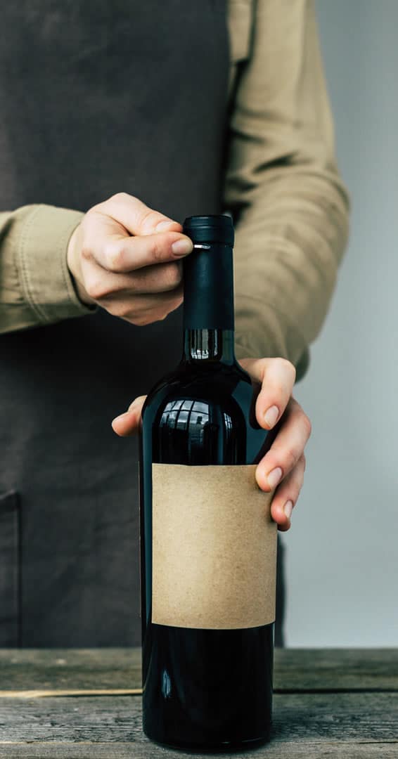 Person opening a bottle of wine.
