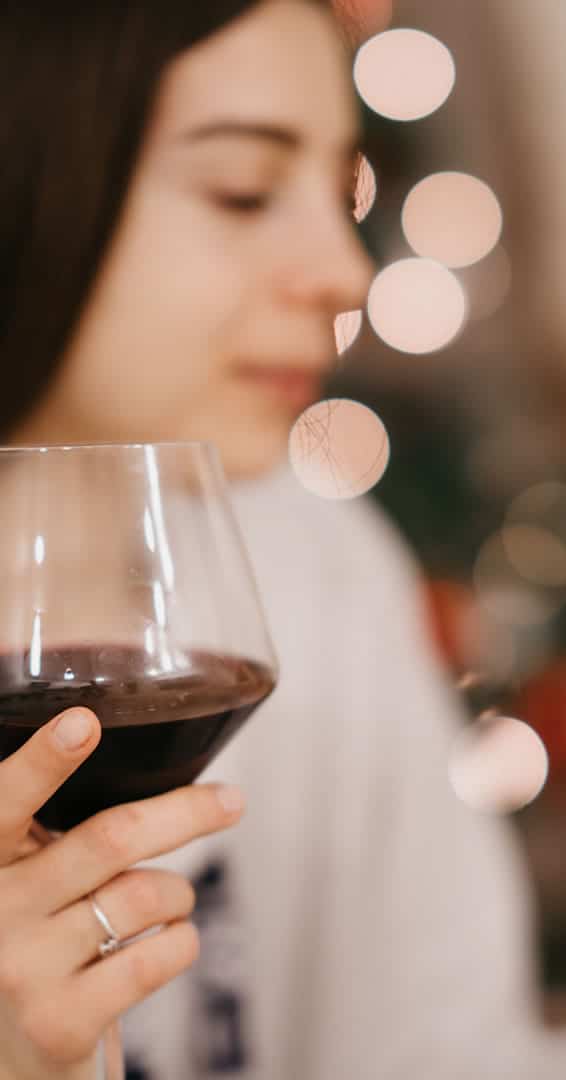 Woman holding a glass of red wine.