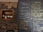 Speaker training tips on blackboard with wine display.
