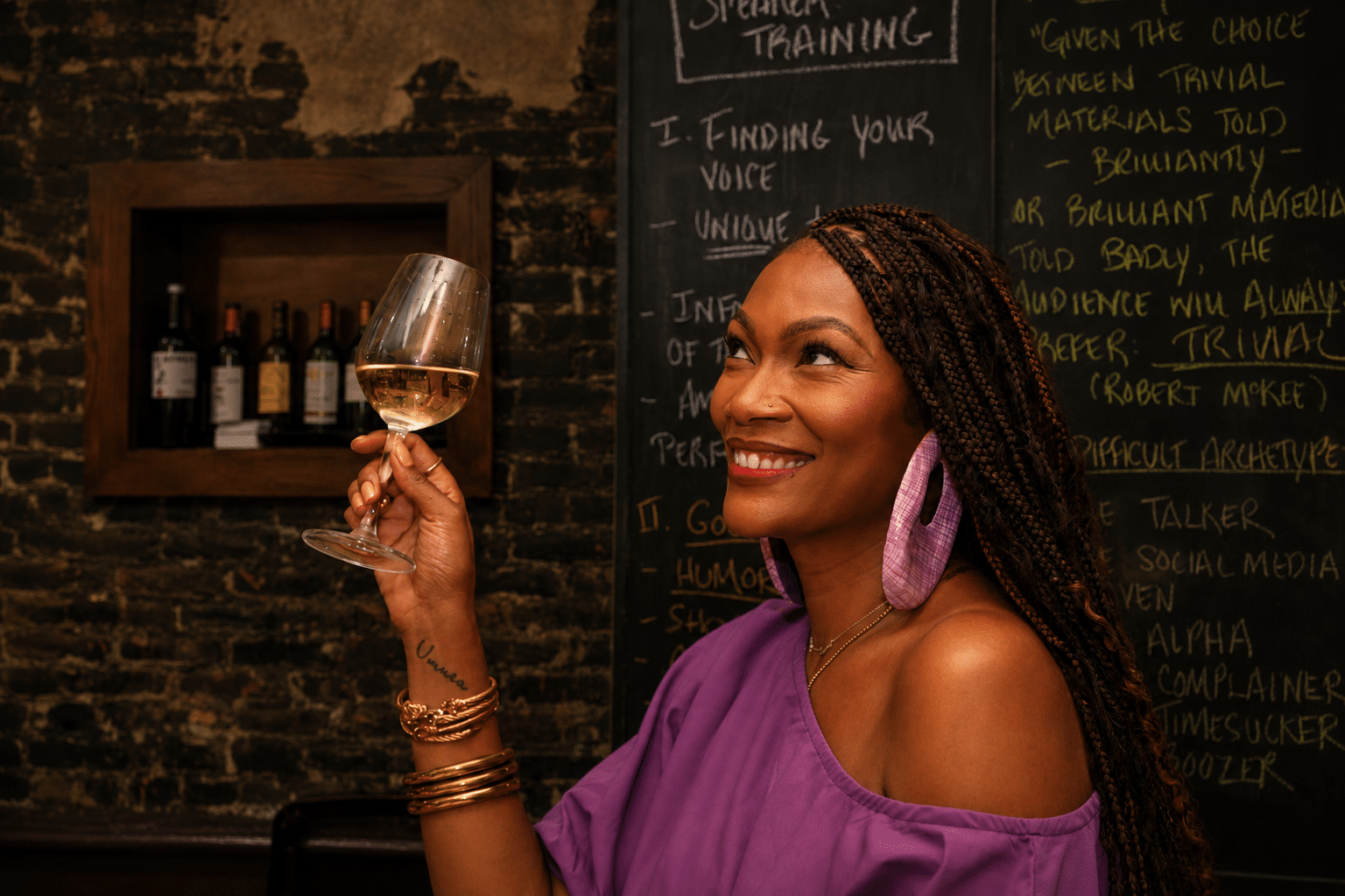 Tahiirah Habibi holding glass of white wine smiling
